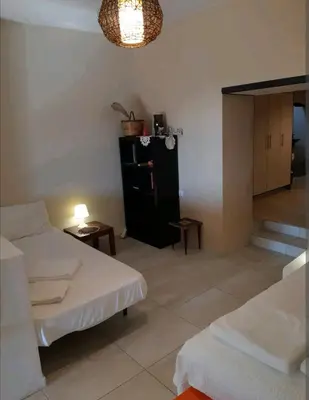 a living room with two beds and a table at Orea Kaliva in Sfinárion