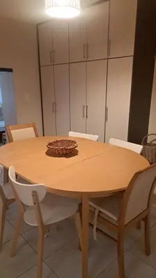a dining room table with chairs and cabinets at Orea Kaliva in Sfinárion