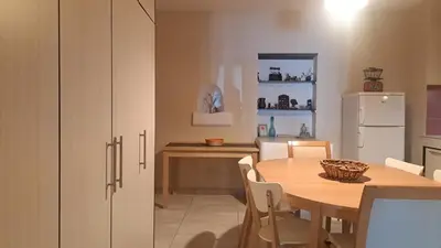 a kitchen with a table and a white refrigerator at Orea Kaliva in Sfinárion
