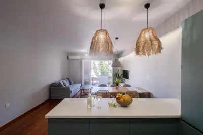 a kitchen and living room with two pendant lights at Chania Central Apartment in Chania Town
