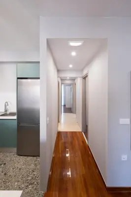 a kitchen with white walls and a wooden floor at Chania Central Apartment in Chania Town