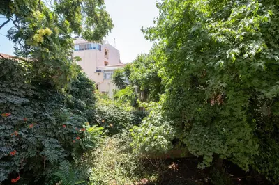 a garden with trees and a building in the background at Chania Central Apartment in Chania Town