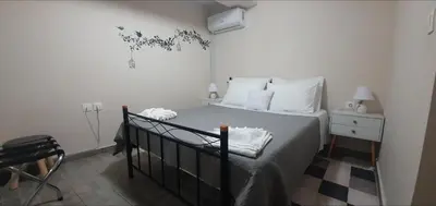 a bedroom with a bed with white pillows and a night stand at Chrisi Traditional House in Néon Khoríon