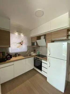 a kitchen with white cabinets and a white refrigerator at MAGIC VIEW APARTMENT in Chania Town