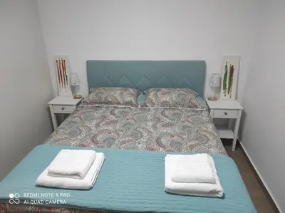 a bed with two nightstands and two towels on it at MAGIC VIEW APARTMENT in Chania Town