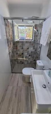 a bathroom with a sink and a toilet and a window at MAGIC VIEW APARTMENT in Chania Town
