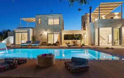 a large swimming pool in front of a house at Annassa Experience Suites 2' walk from Almyrida Beach in Almirida