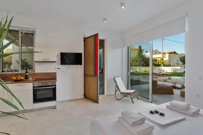 a kitchen and living room with a table and a chair at Annassa Experience Suites 2' walk from Almyrida Beach in Almirida