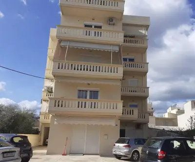 a tall building with cars parked in front of it at NEFELI APARTMENT CHANIA in Chania Town