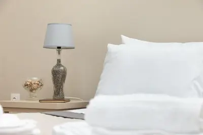 a lamp on a table next to a bed with a pillow at Πλήρως ανακαινισμένη μονοκατοικία. in Chania Town