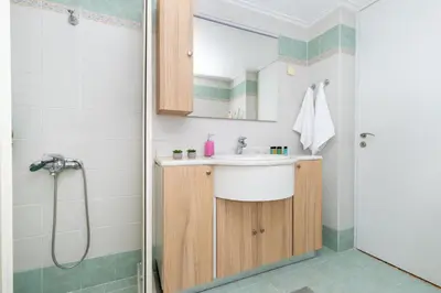 a bathroom with a sink and a shower at Πλήρως ανακαινισμένη μονοκατοικία. in Chania Town