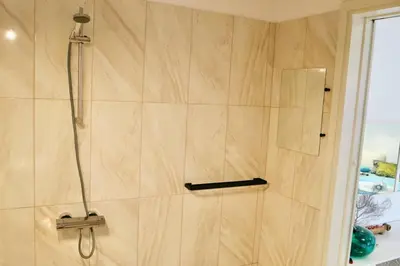 a bathroom with a shower with a glass door at Elpida Seafront Paradise apartment in Crete in Chania Town