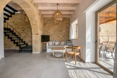 a living room with a brick wall and a table at Alma Natura Villas Falasarna - Aposperitis Villa in Falasarna