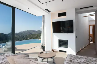 a living room with a fireplace and a tv at Villa Anasa in Palaiochóra