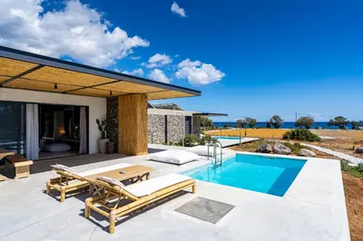 a villa with a swimming pool and a patio at Akra Grammeno Beachfront Villas in Palaiochóra
