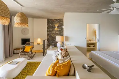 a bedroom with a bed and a living room at Akra Grammeno Beachfront Villas in Palaiochóra