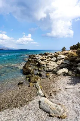 a group of rocks on a beach near the water at Akra Grammeno Beachfront Villas in Palaiochóra