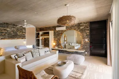a living room with a couch and a mirror at Akra Grammeno Beachfront Villas in Palaiochóra