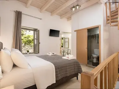 a bedroom with a large bed and a bathroom at Vaggelis house in Chania Town