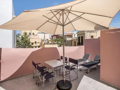 a table and chairs with an umbrella on a balcony at Vaggelis house in Chania Town