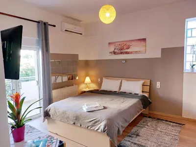 a bedroom with a large bed and a tv at Argy Cozy Apartment (Όμορφο Διαμέρισμα στα Χανιά) in Chania Town