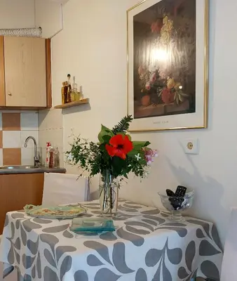 a table with a vase with a red flower on it at Argy Cozy Apartment (Όμορφο Διαμέρισμα στα Χανιά) in Chania Town