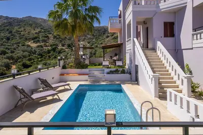 a villa with a swimming pool and a house at Sounds Of The Mountain Chania in Varípetron
