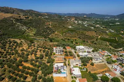 an aerial view of a village with houses and vineyards at Sounds Of The Mountain Chania in Varípetron
