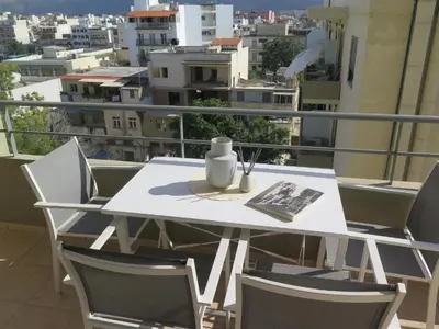 a white table and chairs on a balcony at Alendra's City Center Studio in Chania Town