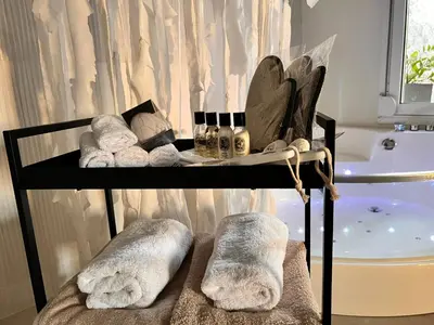 a towel rack with towels and a tub in a bathroom at Perla Coco Jacuzzi Suites in Chania Town