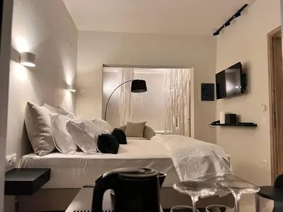 a bedroom with a large bed with white sheets and pillows at Perla Coco Jacuzzi Suites in Chania Town