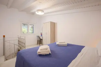 a bedroom with a blue bed with towels on it at Rose of Crete in Plataniás