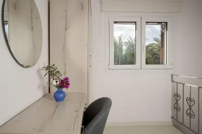 a dining room with a table and a vase of flowers at Rose of Crete in Plataniás
