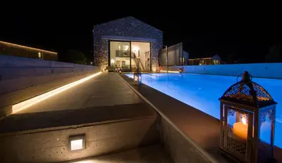 a swimming pool at night with a lantern next to it at Fairytale Villas in Souda