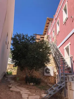 a staircase to a building with a tree next to it at Pink House in Palaiochóra