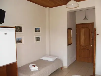 a small bedroom with a bed and a door at Panorama Askifou in Karés