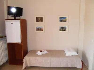 a room with a bed and a tv on a wall at Panorama Askifou in Karés