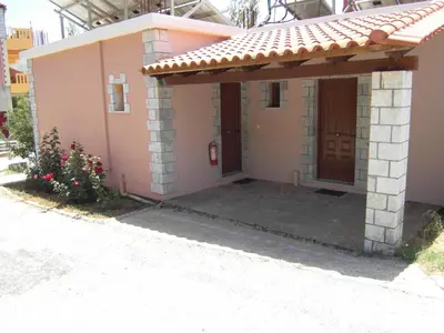 a small pink house with a porch at Panorama Askifou in Karés
