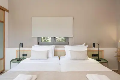 two beds in a bedroom with a window at Elafonisi Resort by Kalomirakis Family in Elafonisi
