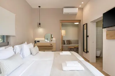 a large white bed in a room with a mirror at Elafonisi Resort by Kalomirakis Family in Elafonisi