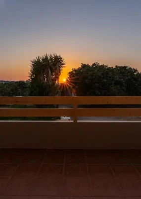 a wooden bench with a sunset in the background at Alexandros Luxury House in Falasarna