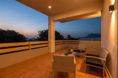 a patio with a table and chairs on a balcony at Alexandros Luxury House in Falasarna