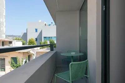 a balcony with a green chair and a table at Souda Plaza Collection in Souda