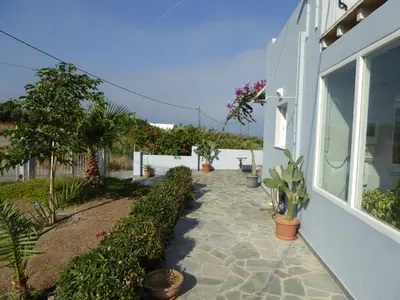 a walkway next to a white house with plants at Elafonisi Vacation Blue Apartment in Agios Padeleimon