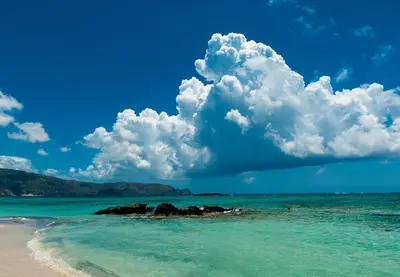 a view of a beach with blue water and clouds at Elafonisi Vacation Blue Apartment in Agios Padeleimon