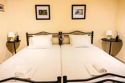 a bedroom with two beds with white sheets and two lamps at Elafonisi Vacation Blue Apartment in Agios Padeleimon