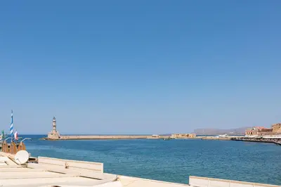 a view of a body of water with white umbrellas at Pasifai Residence - Chania old town in Chania Town
