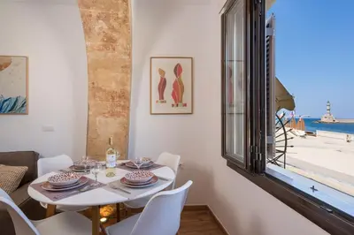 a dining room with a table and chairs and a window at Pasifai Residence - Chania old town in Chania Town