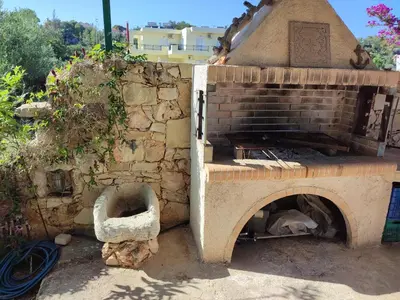 a brick oven sitting next to a stone wall at The Garden of Zephyrus - East in Pithárion