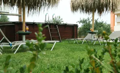 a group of tables and chairs in the grass at Kouros Chania Villas in Maleme